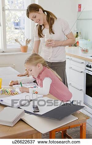 Girl and woman sitting at table working View Large Photo Image Stock Photo - Girl and woman sitting at table working. Fotosearch