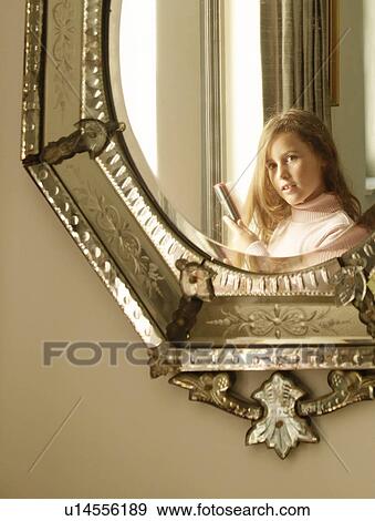 Girl brushing hair in mirror View Large Photo Image Stock Photo - Girl brushing hair in mirror. Fotosearch