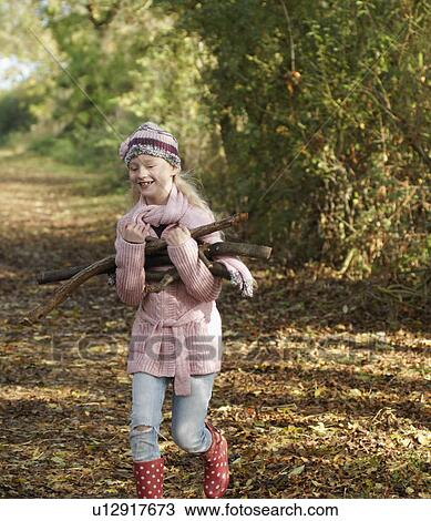 Girl carrying firewood in country View Large Photo Image Stock Image - Girl carrying firewood in country. Fotosearch