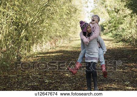Girl carrying friend in countryside View Large Photo Image Picture - Girl carrying friend in countryside. Fotosearch