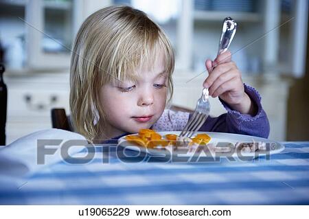 Stock Photo - Girl eating dinner. Fotosearch