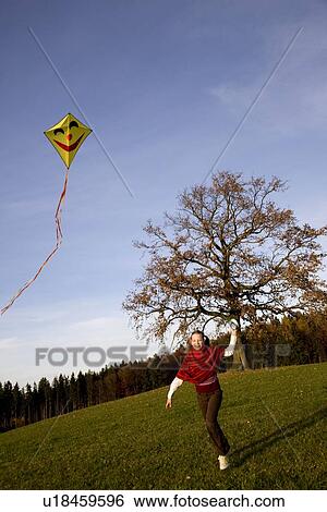 Stock Photograph - Girl flying a Kite. Fotosearch