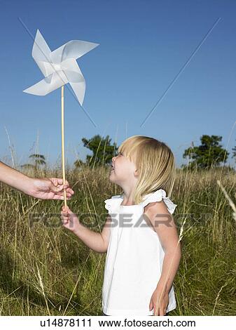 Stock Image - Girl holding a wind-driven. Fotosearch