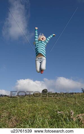 Stock Photo - Girl jumping on hill. Fotosearch