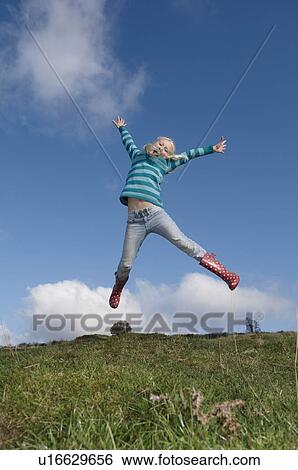 Stock Photograph - Girl jumping on hill. Fotosearch