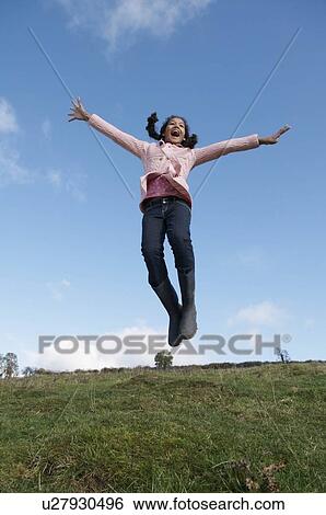 Stock Photograph - Girl jumping on hill. Fotosearch