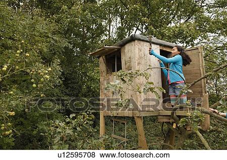 Girl mending treehouse View Large Photo Image Stock Photo - Girl mending treehouse. Fotosearch