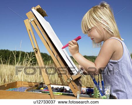 Stock Photo - Girl painting in a field. Fotosearch