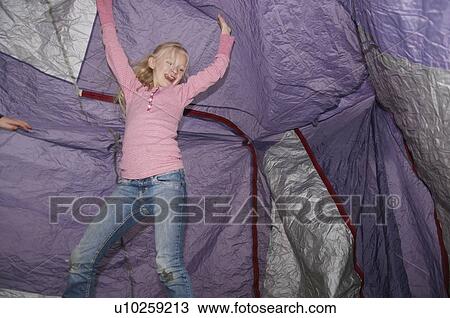 Stock Image - Girl playing under tent. Fotosearch