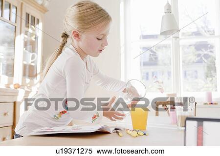 Girl pouring a glass of juice View Large Photo Image Stock Photography - Girl pouring a glass of juice. Fotosearch