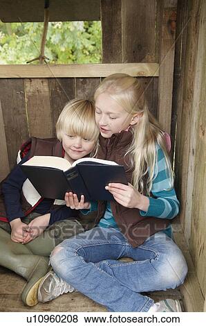 Stock Photo - Girl reading story to young boy. Fotosearch