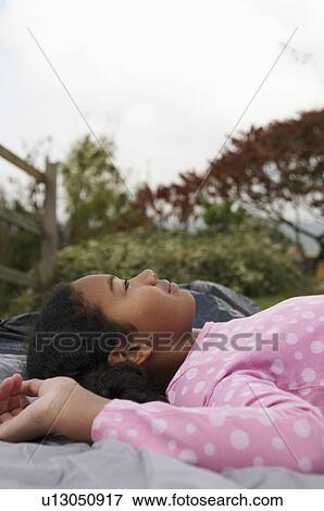 Stock Photo - Girl resting on tent. Fotosearch