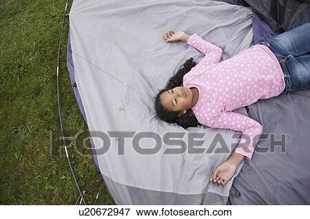 Stock Photo - Girl resting on tent. Fotosearch