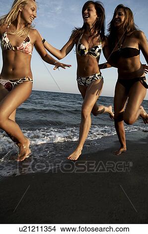Picture - Girl teenagers running on the beach. Fotosearch
