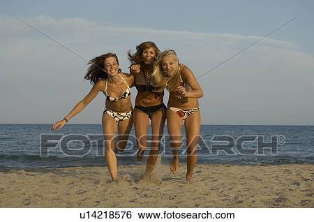 Stock Photograph - Girl teenagers running on the beach. Fotosearch