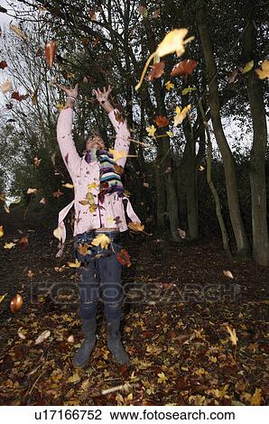 Girl throwing autumn leaves View Large Photo Image Stock Image - Girl throwing autumn leaves. Fotosearch