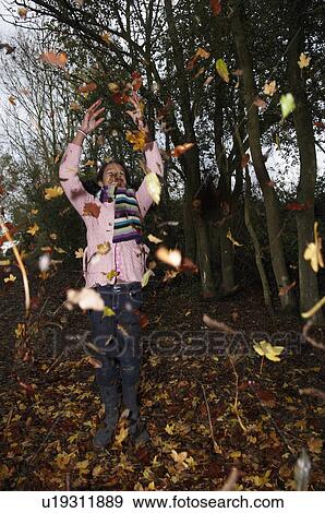 Stock Photo - Girl throwing autumn leaves. Fotosearch