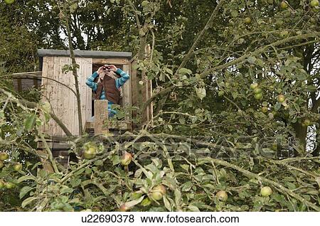 Stock Photo - Girl with binoculars in treehouse. Fotosearch