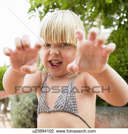 Stock Image - "Girl with food in mouth, making a face". Fotosearch