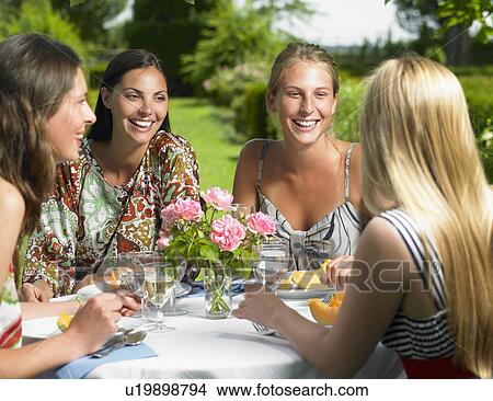 Picture - Girlfriends having lunch outdoors. Fotosearch