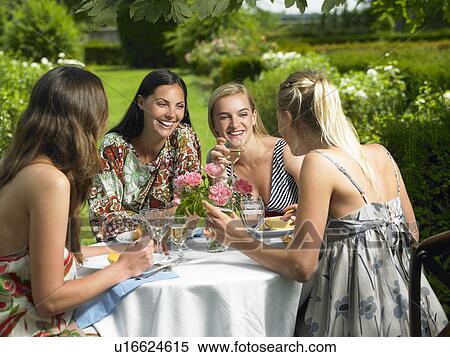 Stock Photography - Girlfriends having lunch outdoors. Fotosearch