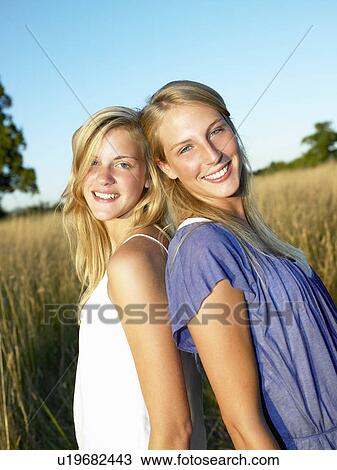 "Girlfriends in a field, smiling" View Large Photo Image Stock Image - "Girlfriends in a field, smiling". Fotosearch