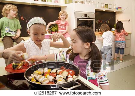 Girls and boys cooking vegetables View Large Photo Image Stock Photo - Girls and boys cooking vegetables. Fotosearch