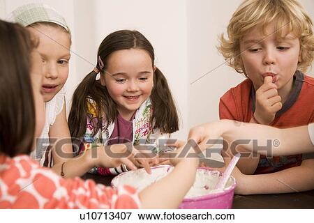 Stock Photo - Girls and boys tasting dish. Fotosearch