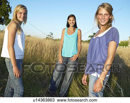 Stock Image - "Girls in a field, smiling". Fotosearch