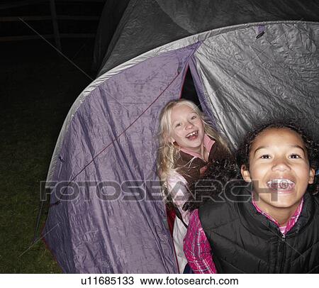 Stock Image - Girls in tent at bedtime. Fotosearch