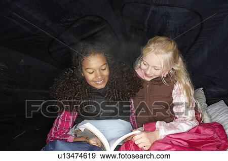 Girls reading in tent View Large Photo Image Stock Photo - Girls reading in tent. Fotosearch