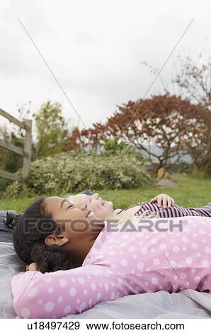 Stock Photo - Girls resting on tent. Fotosearch