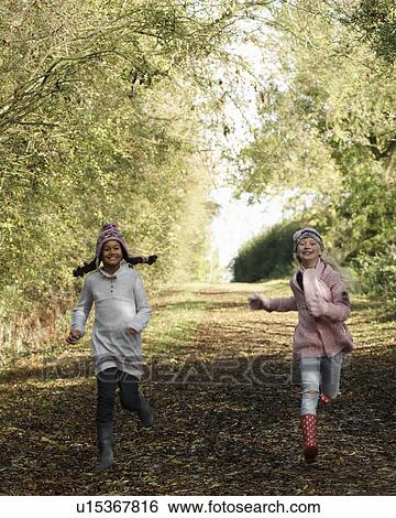 Stock Photograph - Girls running down country lane. Fotosearch