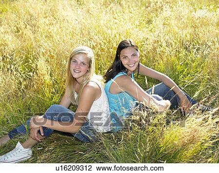 Girls seated in a field View Large Photo Image Stock Image - Girls seated in a field. Fotosearch