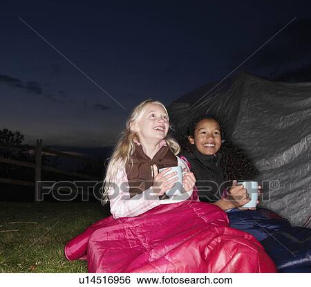 Stock Photograph - Girls with hot drink near tent. Fotosearch