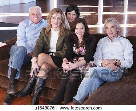 Stock Image - Group of friends sitting on sofa. Fotosearch