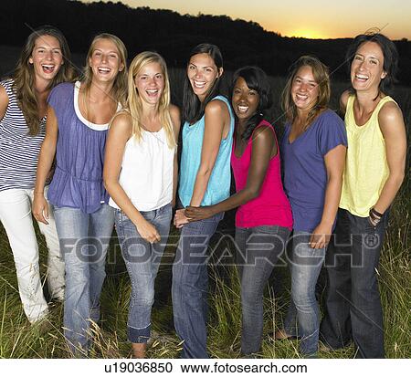 Group of girlfriends laughing in a field View Large Photo Image Stock Image - Group of girlfriends laughing in a field. Fotosearch