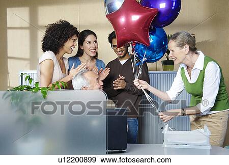Stock Photo - Group of people celebrating co-worker. Fotosearch