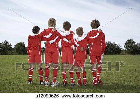 Group of young footballers from behind View Large Photo Image Stock Photograph - Group of young footballers from behind. Fotosearch