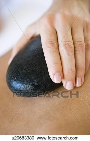 Stock Image - Hand holding hot stone. Fotosearch