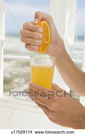 Picture - Hand squeezing orange juice. Fotosearch