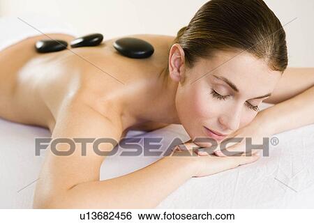 Hot stones laying on woman's back View Large Photo Image Stock Photograph - Hot stones laying on woman's back. Fotosearch