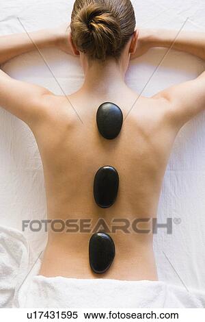 Stock Photography - Hot stones laying on woman's back. Fotosearch