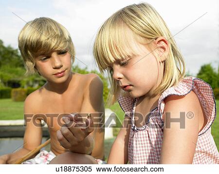 Stock Photography - Kids looking at a tadpole. Fotosearch
