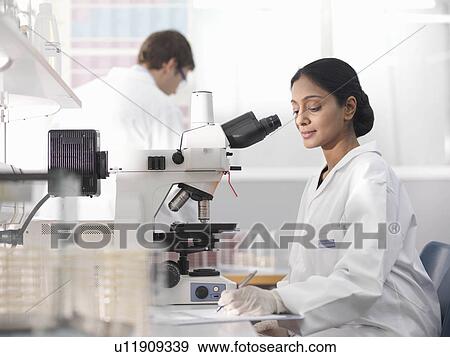 Stock Photo - Laboratory technician and microscope. Fotosearch