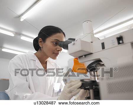 Stock Photo - Laboratory technician with microscope. Fotosearch