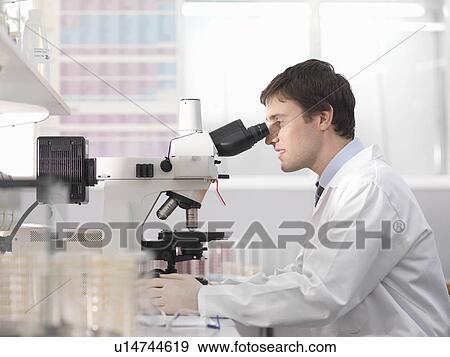Stock Photo - Laboratory technician with microscope. Fotosearch