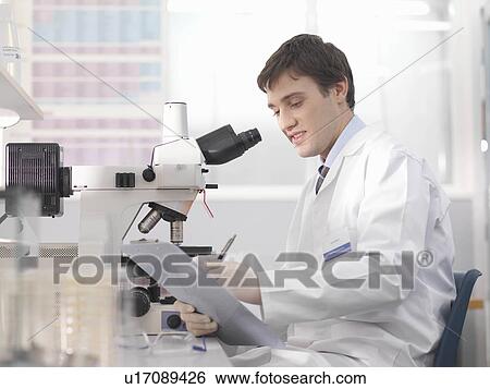 Stock Photograph - Laboratory technician with microscope. Fotosearch