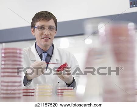 Stock Image - Laboratory technician with petri dish. Fotosearch