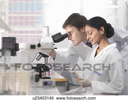 Stock Photography - Laboratory technicians and microscope. Fotosearch